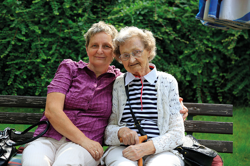 Seniorin auf Bank im Garten